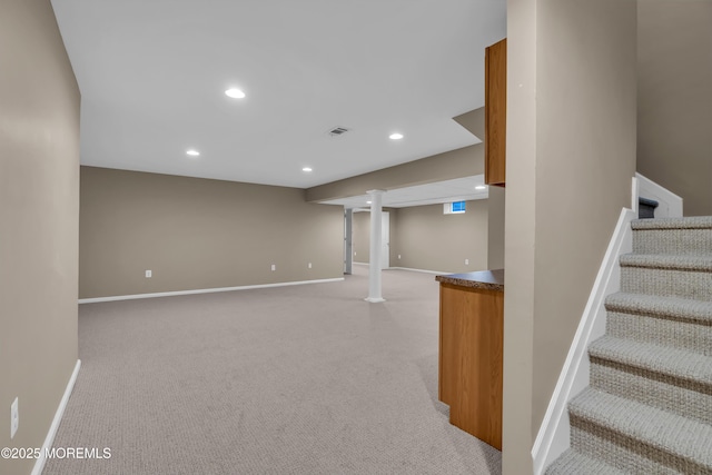 finished basement featuring recessed lighting, light colored carpet, stairs, and baseboards