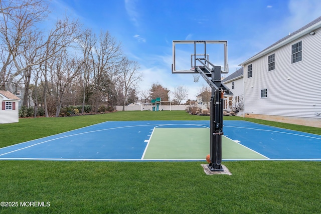 view of sport court with basketball hoop, a lawn, fence, and a playground