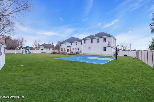 view of sport court featuring a fenced backyard, a lawn, a playground, and basketball hoop