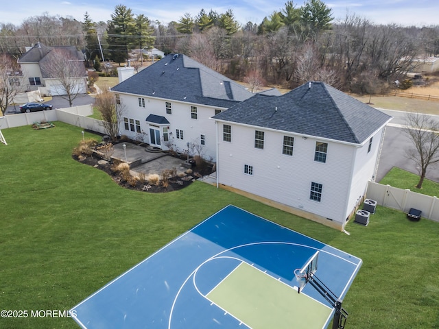 view of sport court featuring basketball court, a fenced backyard, and a yard