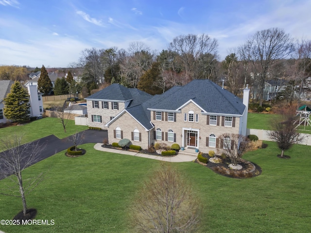 view of front of property featuring a chimney, a front lawn, and fence