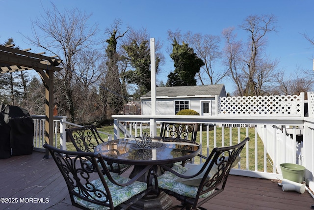 wooden terrace with outdoor dining area, a yard, an outdoor structure, a grill, and a pergola