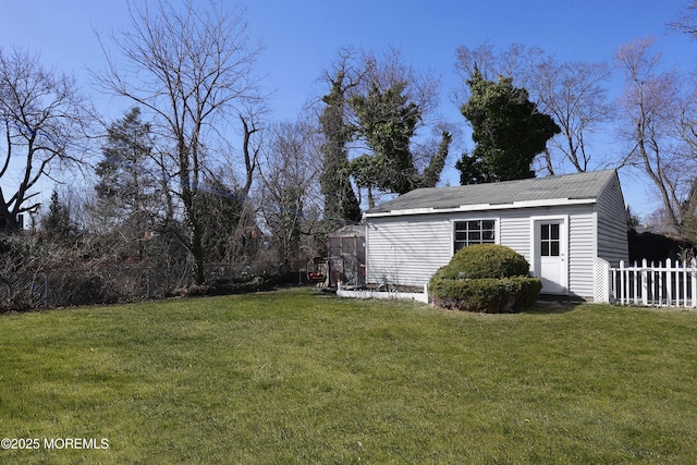 view of yard featuring an outbuilding and fence