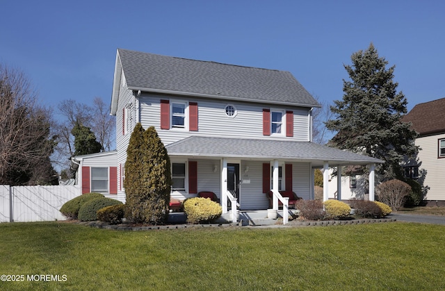 view of front of property with a front yard, fence, covered porch, and roof with shingles