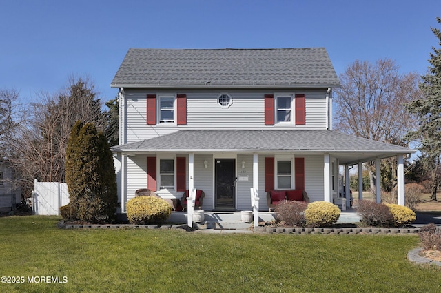 view of front facade with roof with shingles, a porch, a front yard, and fence