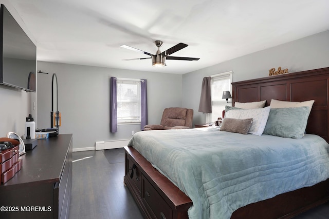 bedroom with a baseboard radiator, multiple windows, dark wood-type flooring, and baseboards