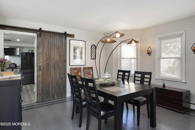 dining room with dark wood-style floors and a barn door