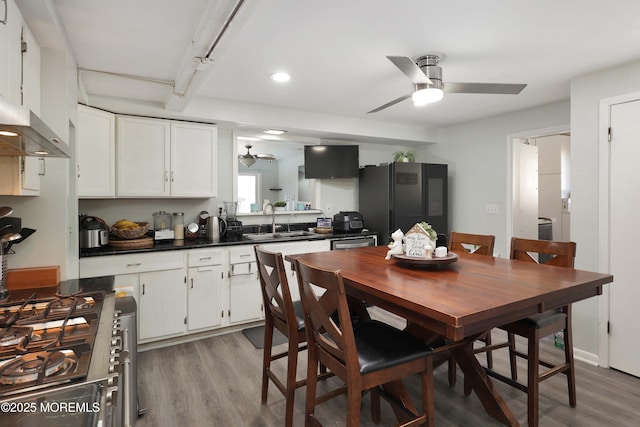 kitchen featuring dark countertops, light wood-style flooring, freestanding refrigerator, and a sink