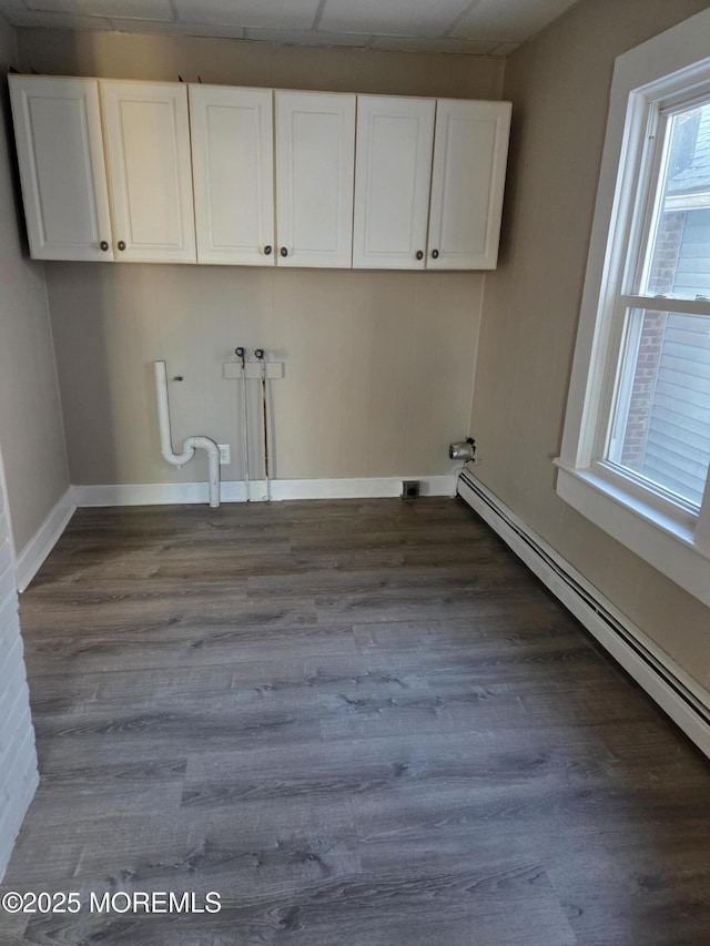 washroom with hookup for a washing machine, cabinet space, baseboard heating, and dark wood-style floors