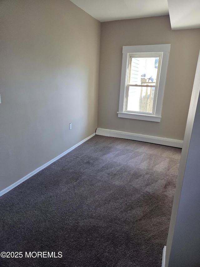 carpeted empty room featuring baseboards