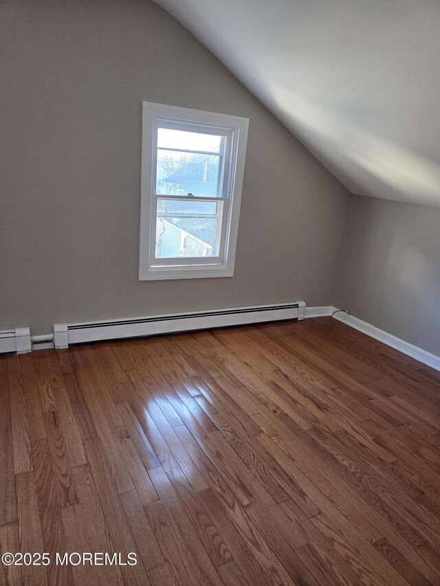 bonus room with baseboards, a baseboard heating unit, lofted ceiling, and wood finished floors