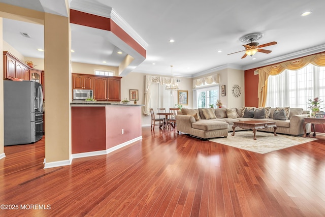 living room featuring crown molding, recessed lighting, wood finished floors, and baseboards