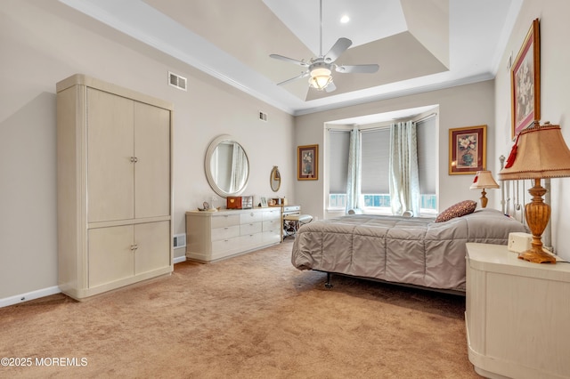 bedroom featuring a raised ceiling, crown molding, visible vents, and light carpet