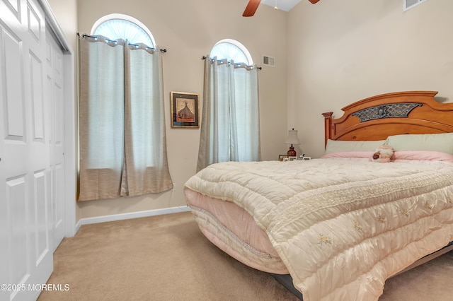 bedroom with visible vents, ceiling fan, carpet, multiple windows, and a closet