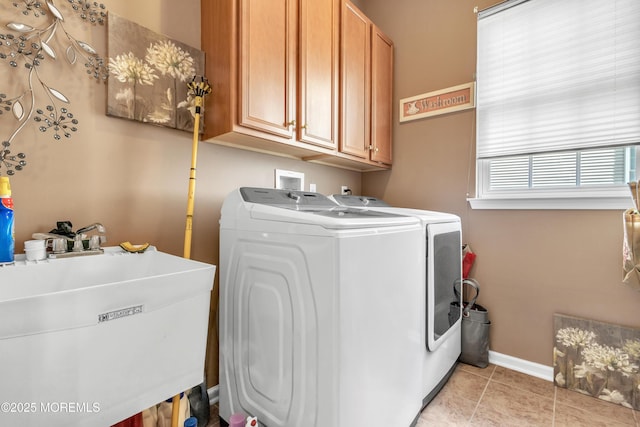 laundry room with washer and clothes dryer, a sink, cabinet space, light tile patterned floors, and baseboards