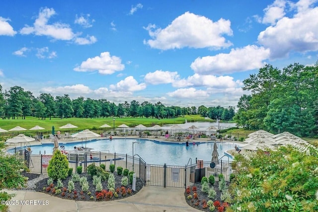 pool with a gate, a water view, and fence