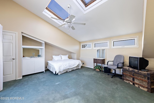 carpeted bedroom with vaulted ceiling with skylight and a ceiling fan