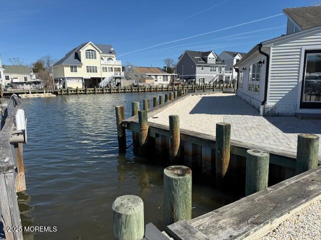 dock area featuring a residential view and a water view