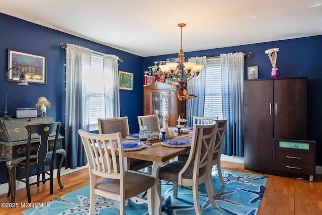 dining space featuring an inviting chandelier and wood finished floors