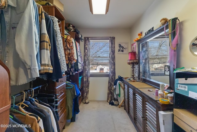 walk in closet featuring light colored carpet