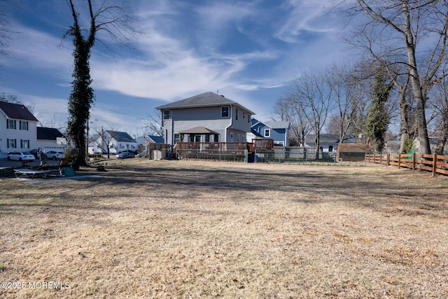 view of yard with a deck, fence, and a residential view