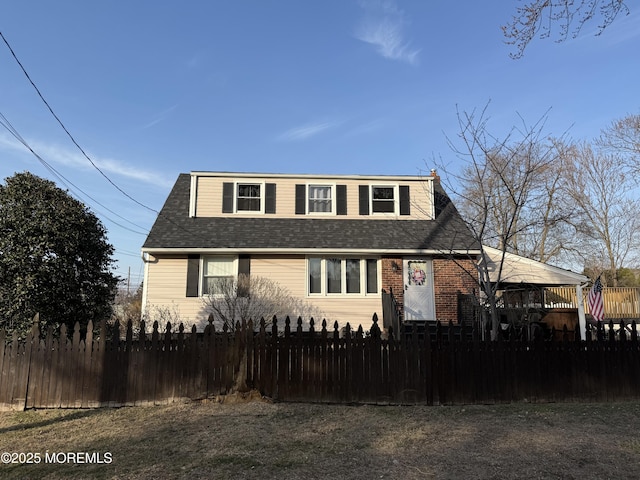 bungalow-style home featuring a fenced front yard and roof with shingles