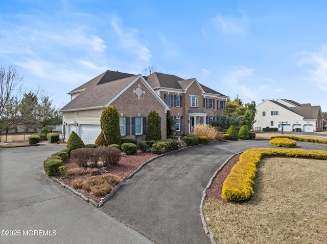 georgian-style home featuring aphalt driveway and a garage