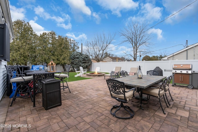 view of patio / terrace with outdoor dining space, an outdoor fire pit, and a fenced backyard