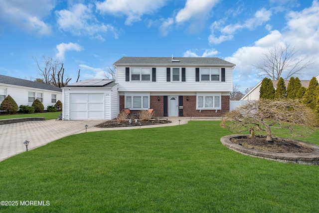 colonial house featuring brick siding, fence, a front yard, decorative driveway, and an attached garage