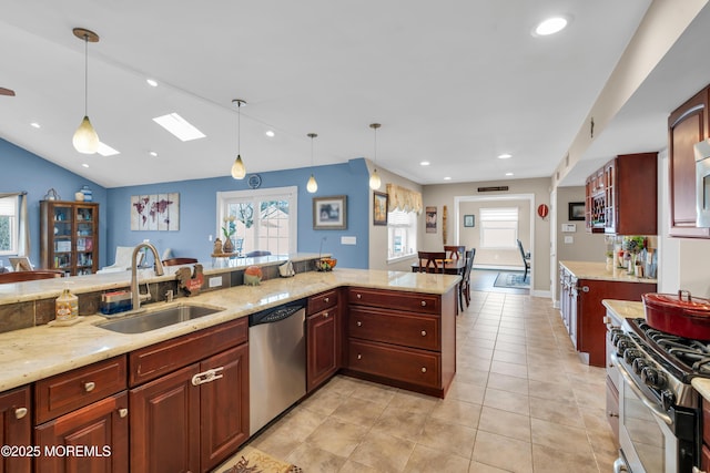 kitchen with a healthy amount of sunlight, appliances with stainless steel finishes, pendant lighting, and a sink