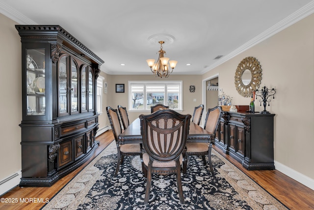 dining space featuring visible vents, a baseboard heating unit, crown molding, baseboard heating, and a chandelier