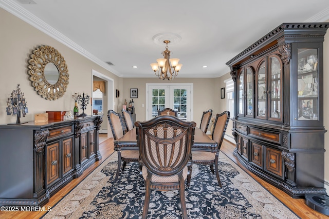 dining area with recessed lighting, an inviting chandelier, ornamental molding, and light wood finished floors