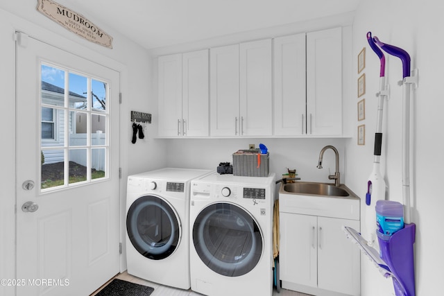 washroom featuring cabinet space, independent washer and dryer, and a sink