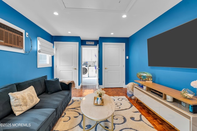 living room with baseboards, washing machine and clothes dryer, attic access, recessed lighting, and an AC wall unit