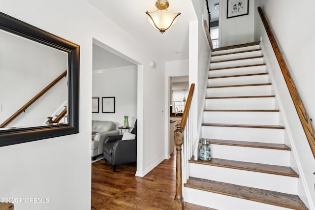 staircase featuring baseboards and wood finished floors