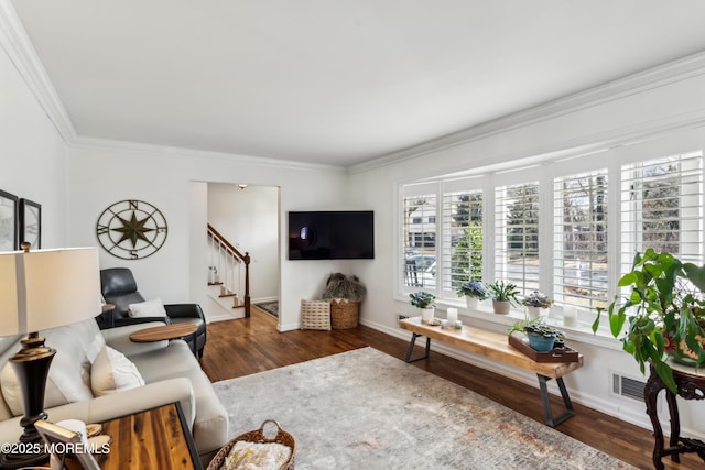 living room with stairway, wood finished floors, baseboards, and ornamental molding