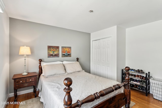 bedroom featuring a closet, baseboards, and wood finished floors