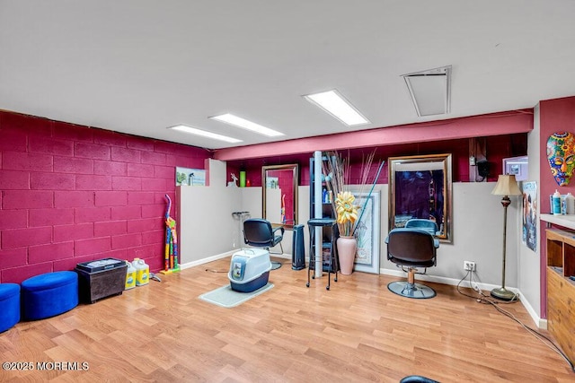 interior space with baseboards, wood finished floors, and concrete block wall