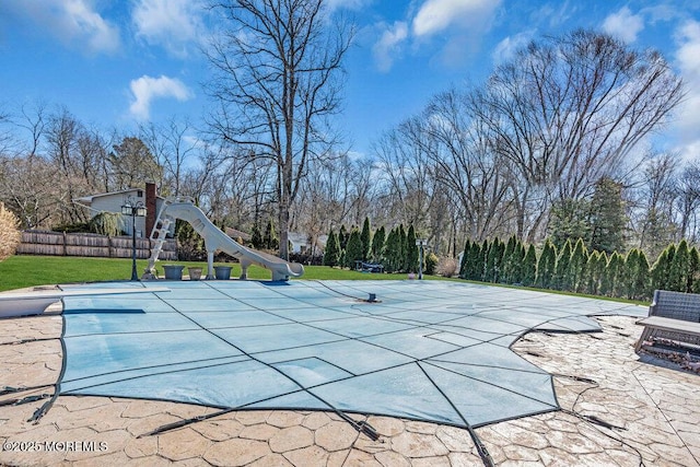 view of pool with a patio area, a yard, and fence