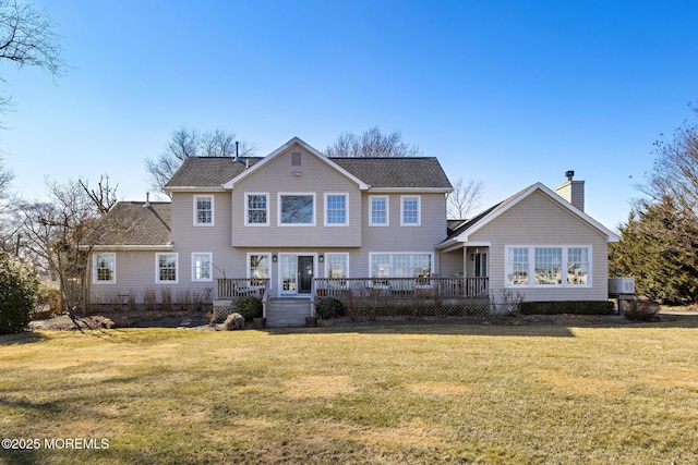 view of front of property with a front yard, a deck, and a chimney