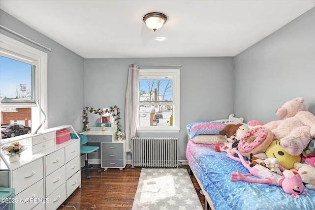 bedroom with dark wood finished floors and radiator heating unit