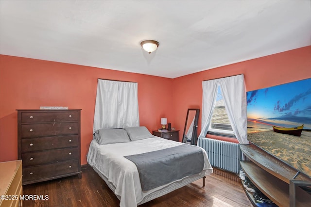 bedroom with radiator and wood finished floors