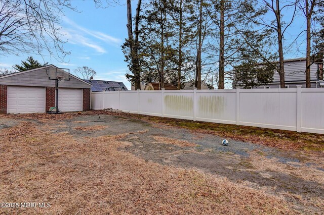 view of yard featuring an outdoor structure, fence, and a garage