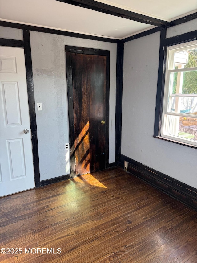 empty room featuring hardwood / wood-style floors and baseboards