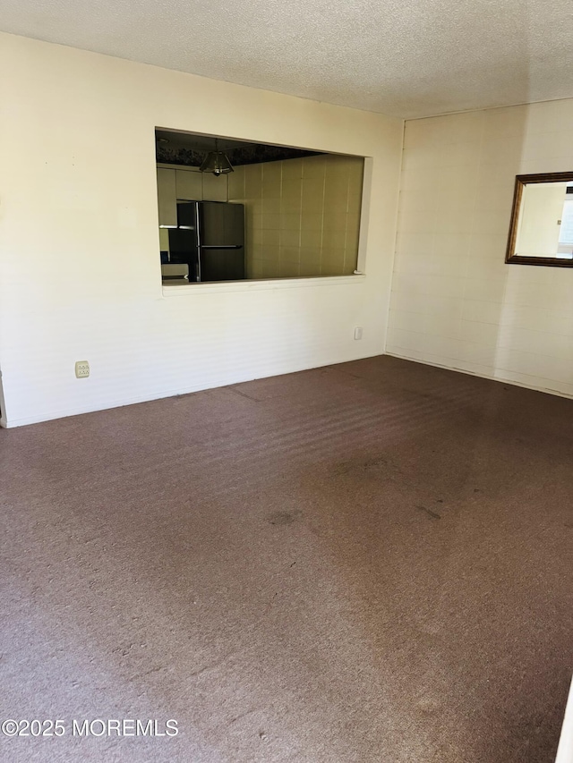 carpeted empty room with a textured ceiling