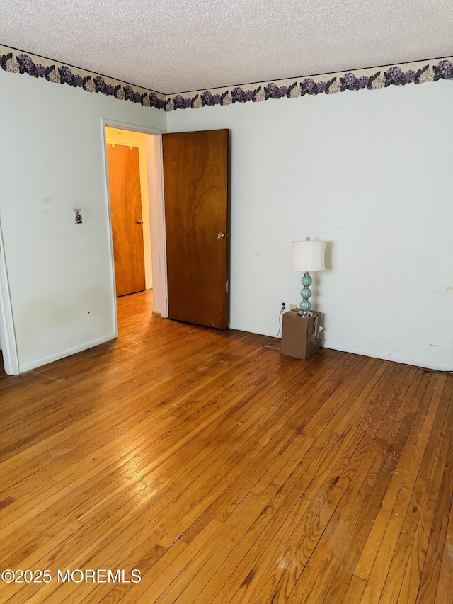 spare room with light wood-style flooring and a textured ceiling