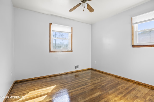 spare room featuring visible vents, baseboards, ceiling fan, and hardwood / wood-style flooring