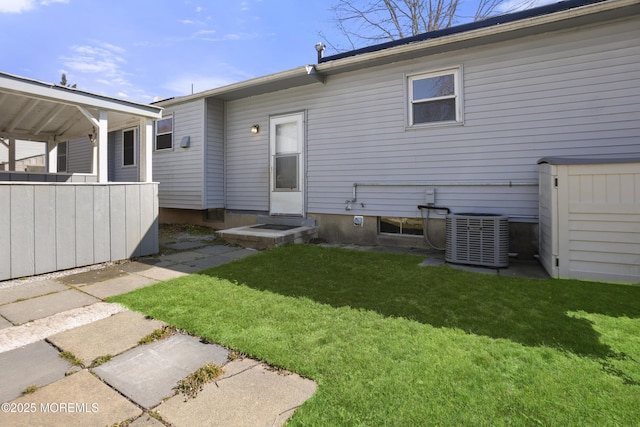 back of property with a yard and central AC unit