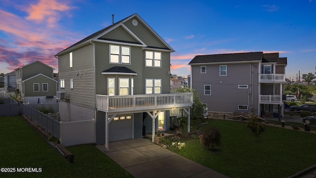 view of front of property featuring an attached garage, central AC, a yard, and driveway