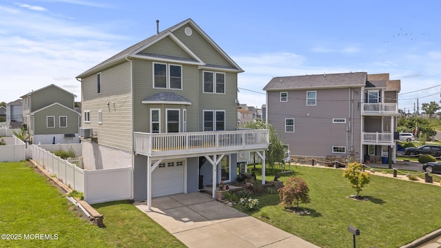 view of front of home with fence, concrete driveway, a front yard, cooling unit, and a garage